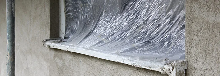 Abgeklebtes Fenster beim Verputzen